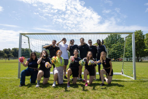 Group photo of the team in front of a goal.